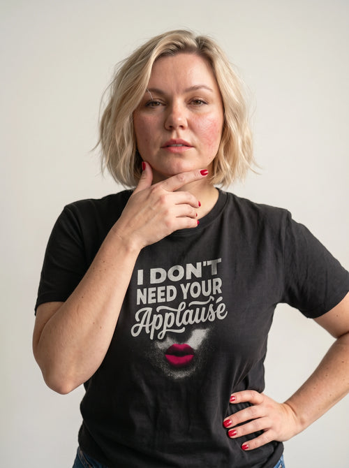 gravisk I Don't Need Your Applause organic graphic tee. A face dissolving into particles, only pink lips intact, Applause in script.