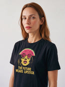 Person trägt das gravisk The Future Wears Lipstick Grafik-T-Shirt, Porträt im Plakatstil mit senfgelber Schrift.