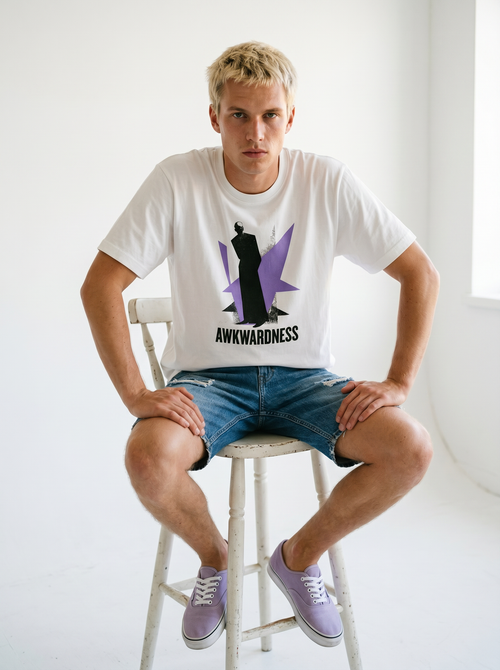 gravisk Awkwardness organic graphic tee. A dark figure in front of a lavender starburst, AWKWARDNESS in black caps below.