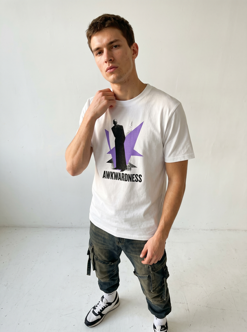 gravisk Awkwardness organic graphic tee. A dark figure in front of a lavender starburst, AWKWARDNESS in black caps below.