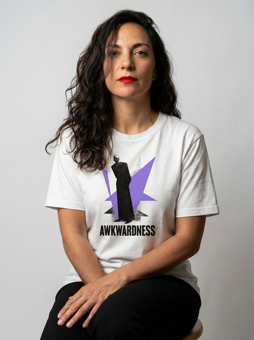 gravisk Awkwardness organic graphic tee. A dark figure in front of a lavender starburst, AWKWARDNESS in black caps below.