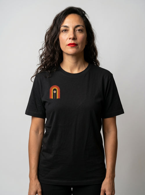 gravisk Bloom Arch organic graphic tee. Left-chest arch in amber and burnt orange, a single flower growing inside.