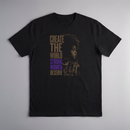 gravisk Create The World Strong Women Deserve organic graphic tee. A woman's profile beside a city skyline, gold type with STRONG WOMEN in purple.