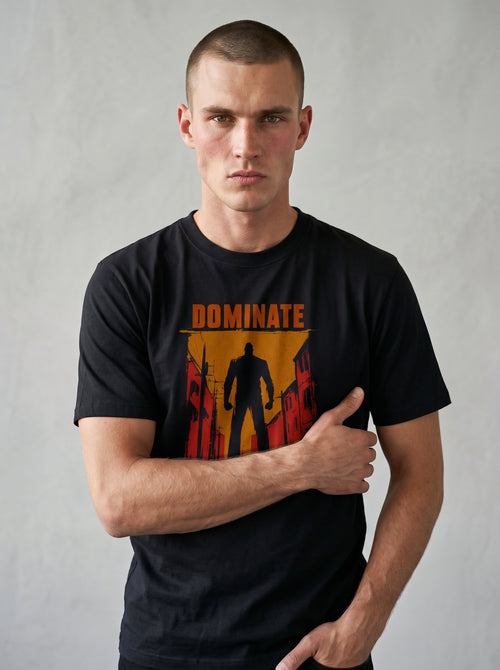 gravisk Dominate organic graphic tee. A lone silhouette in a burning amber street, DOMINATE in heavy caps above.