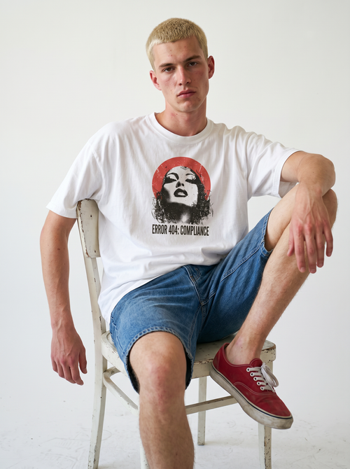 gravisk Error 404: Compliance organic graphic tee. Distressed portrait in a red circle, monospace ERROR 404: COMPLIANCE type.