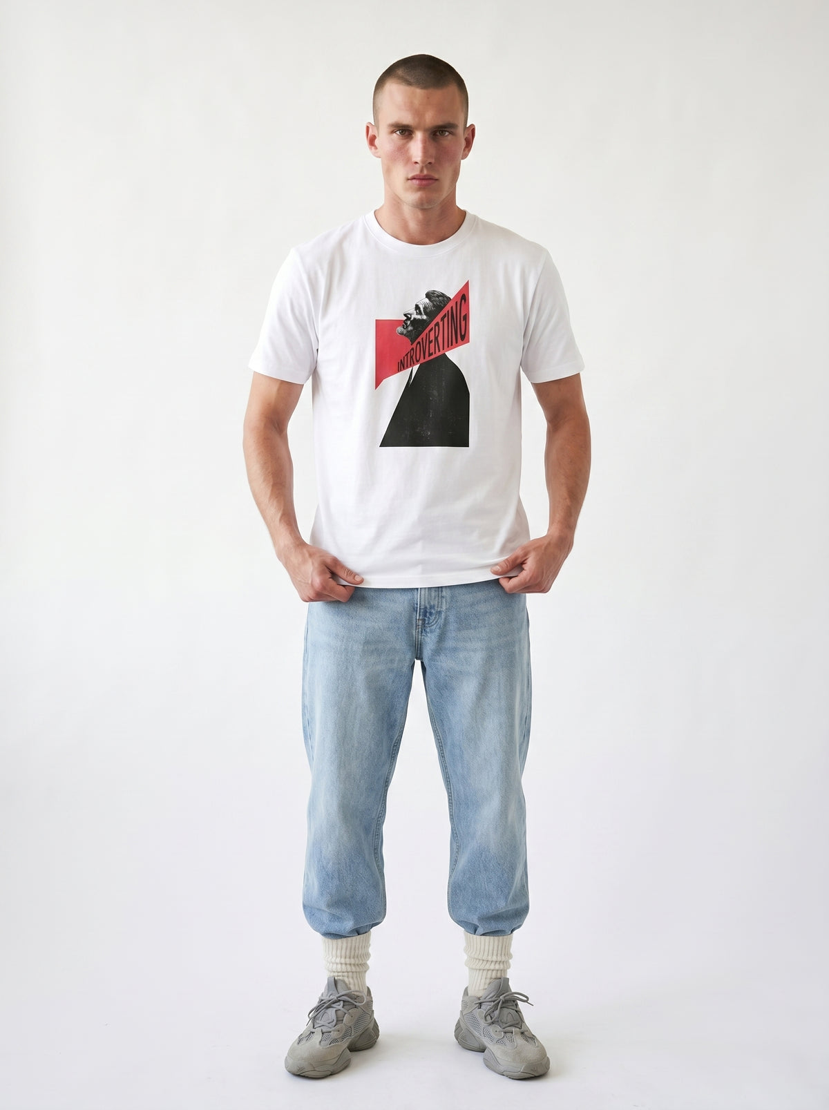 gravisk Introverting organic graphic tee. A tilted profile portrait cut by a red diagonal band reading INTROVERTING.