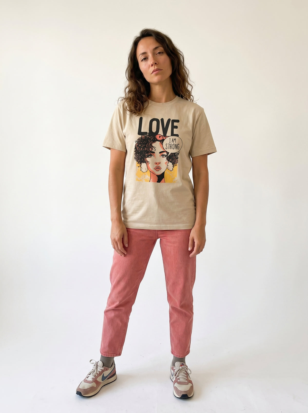 gravisk Love. I Am Strong organic graphic tee. Comic-style portrait with an I AM STRONG speech bubble, LOVE above.