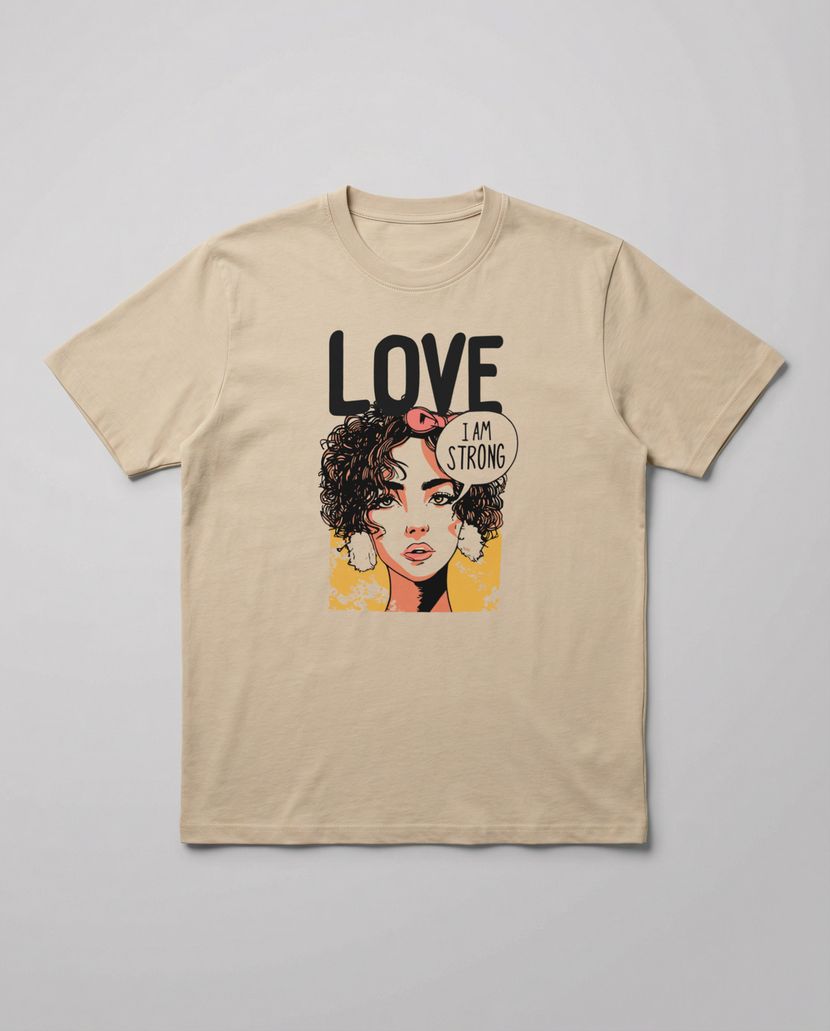 gravisk Love. I Am Strong organic graphic tee. Comic-style portrait with an I AM STRONG speech bubble, LOVE above.