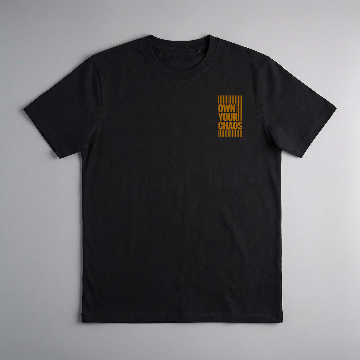 gravisk Own Your Chaos organic graphic tee. Compact amber chest print framed in thin bars.