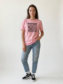 gravisk Resistance organic graphic tee. Hand-drawn panel of plants, faces and symbols in black line work, RESISTANCE above.
