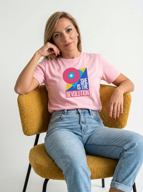 gravisk She Is the Revolution organic graphic tee. Bold geometric shapes in pink, blue and yellow around SHE IS THE REVOLUTION.