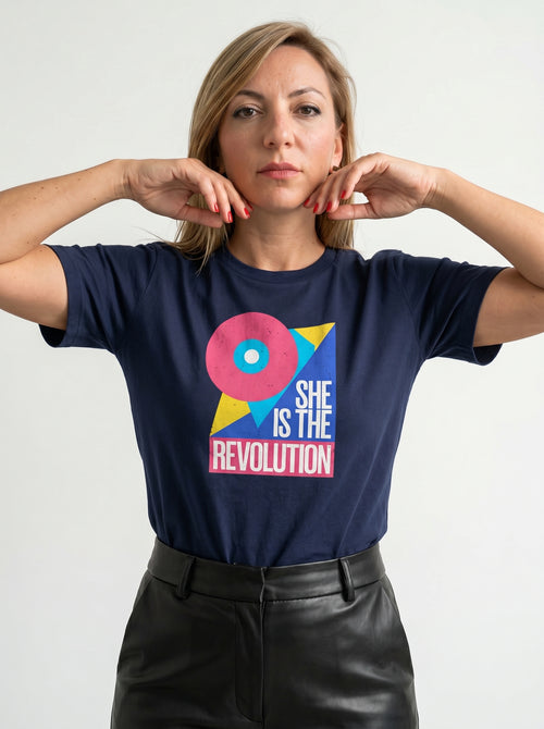 gravisk She Is the Revolution organic graphic tee. Bold geometric shapes in pink, blue and yellow around SHE IS THE REVOLUTION.