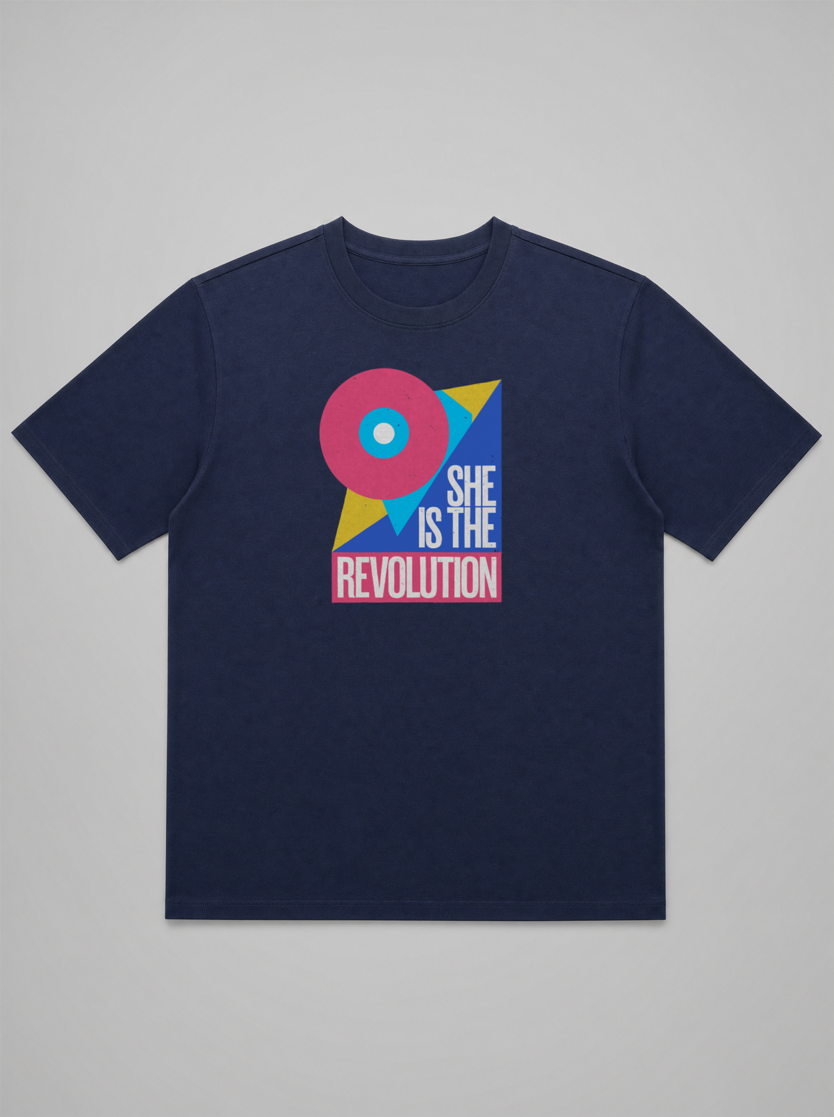 gravisk She Is the Revolution organic graphic tee. Bold geometric shapes in pink, blue and yellow around SHE IS THE REVOLUTION.