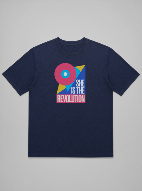 gravisk She Is the Revolution organic graphic tee. Bold geometric shapes in pink, blue and yellow around SHE IS THE REVOLUTION.