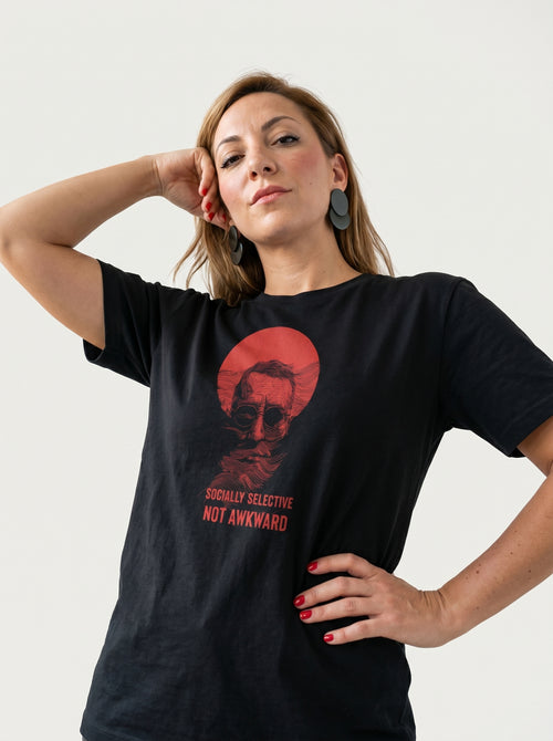 gravisk Socially Selective, Not Awkward organic graphic tee. A man in round glasses, hand over his mouth, inside a red circle.
