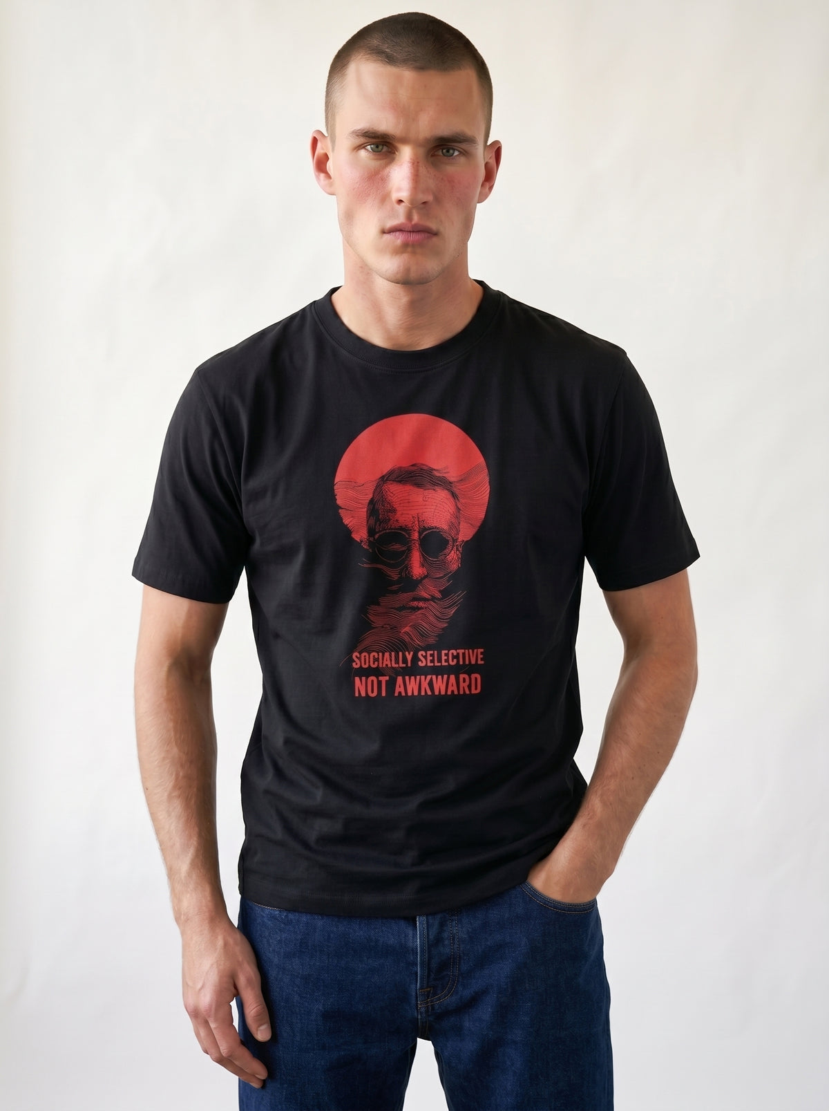 gravisk Socially Selective, Not Awkward organic graphic tee. A man in round glasses, hand over his mouth, inside a red circle.