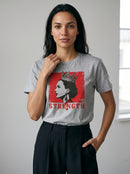 gravisk Strength organic graphic tee. A crowned profile on a distressed red square, STRENGTH in red serif.