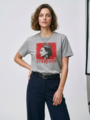 gravisk Strength organic graphic tee. A crowned profile on a distressed red square, STRENGTH in red serif.